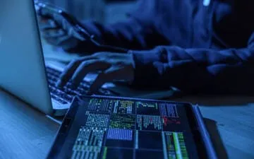 O que são ataques DDoS? Na imagem, criminoso virtual tentando atacar uma empresa, cenário que mostra a importância de contratar seguro cyber para empresas.