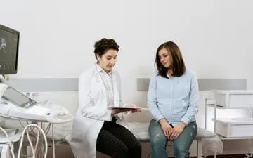 O que é RC Clínica Médica? Na imagem, médica atende paciente e explica diagnóstico. Reprodução/Pexels