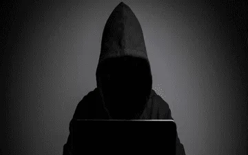 O que é roubo de dados na internet e como evitar? Na imagem, representação de um hacker em alusão à importância de as empresas contratarem o seguro cyber.
