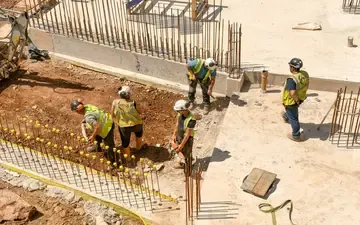 Seguro de responsabilidade civil obras: o que é? Na imagem, funcionários de uma empresa de construção trabalhando em um projeto protegido pelo seguro risco de engenharia.